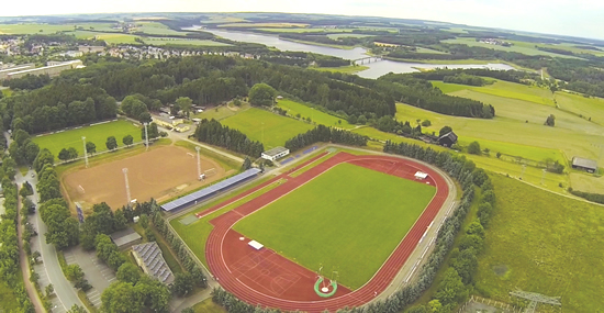 Blick auf das Waldstadion Zeulenroda mit Talsperre im Hintergrund